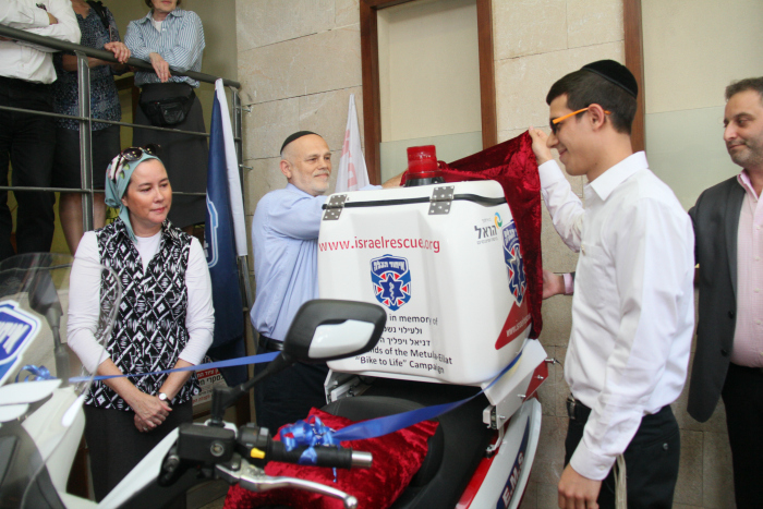 Daniel Shore and the parents of Daniel Vilfic unveil the ambucycle dedicated in Daniel Vilfic's honor